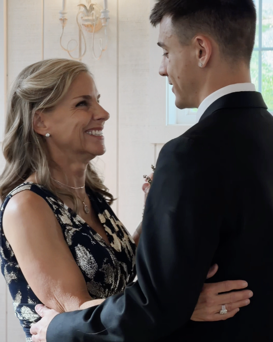 Mother of the groom smiling with her son before the ceremony