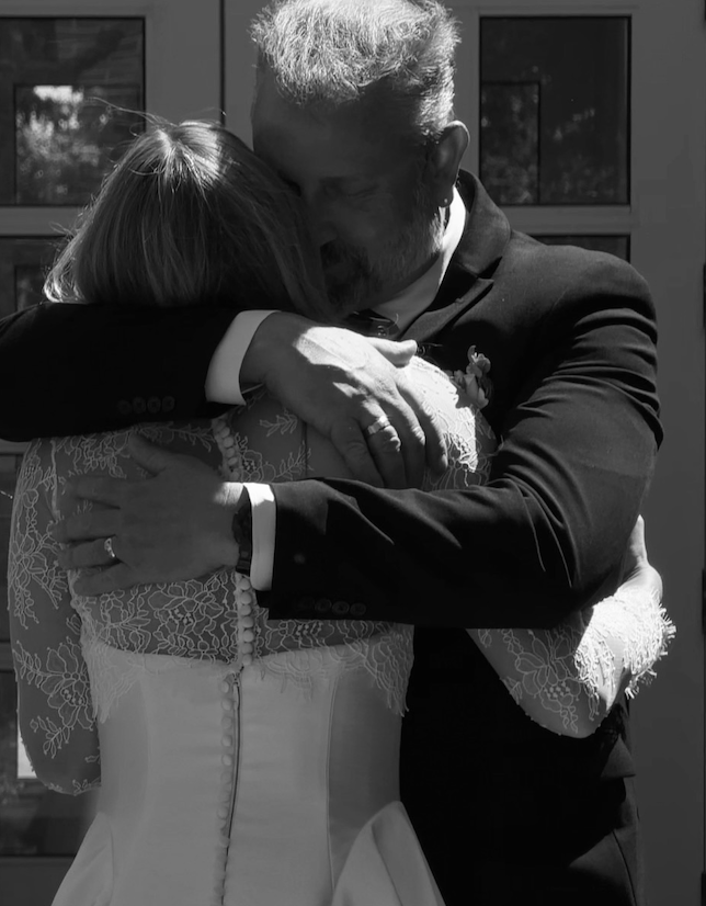 Black and white photo of the father of the bride embracing his daughter
