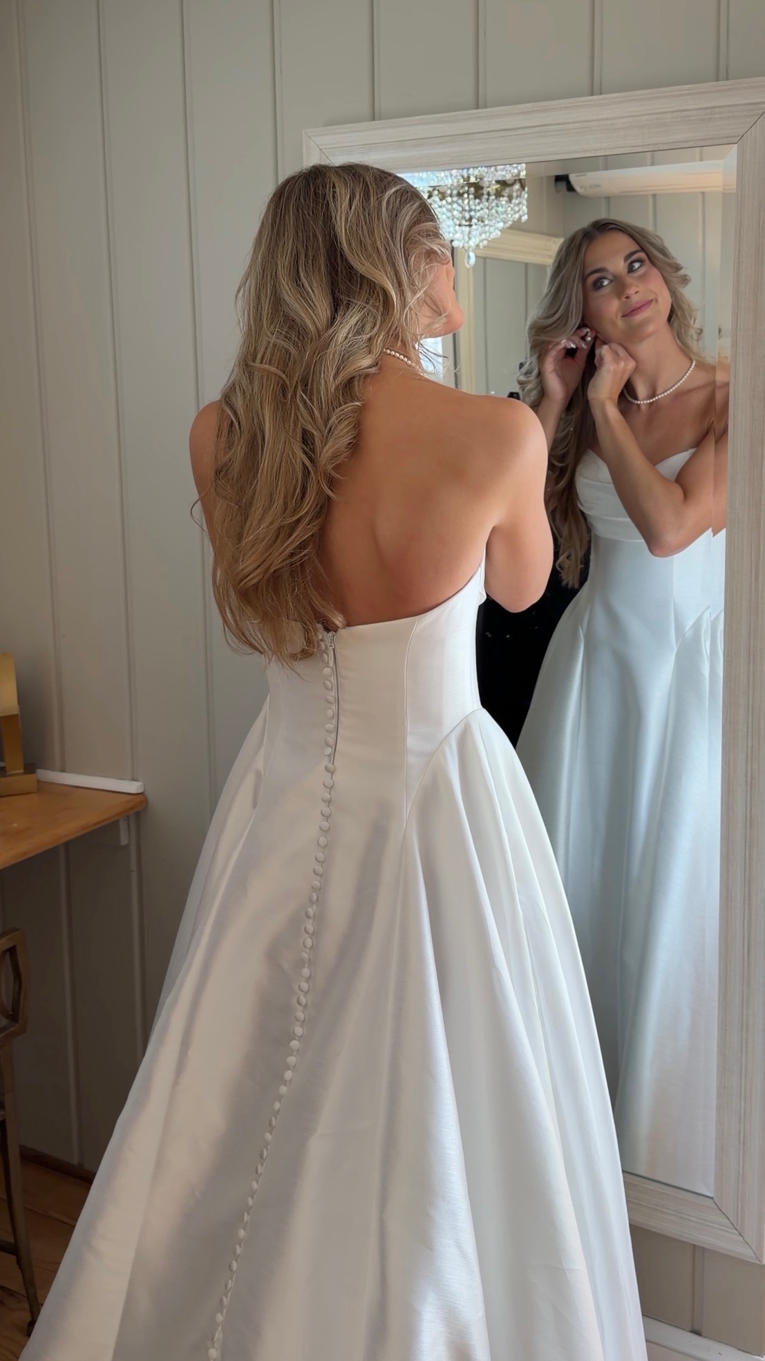 Bride in her gown reflected in the mirror