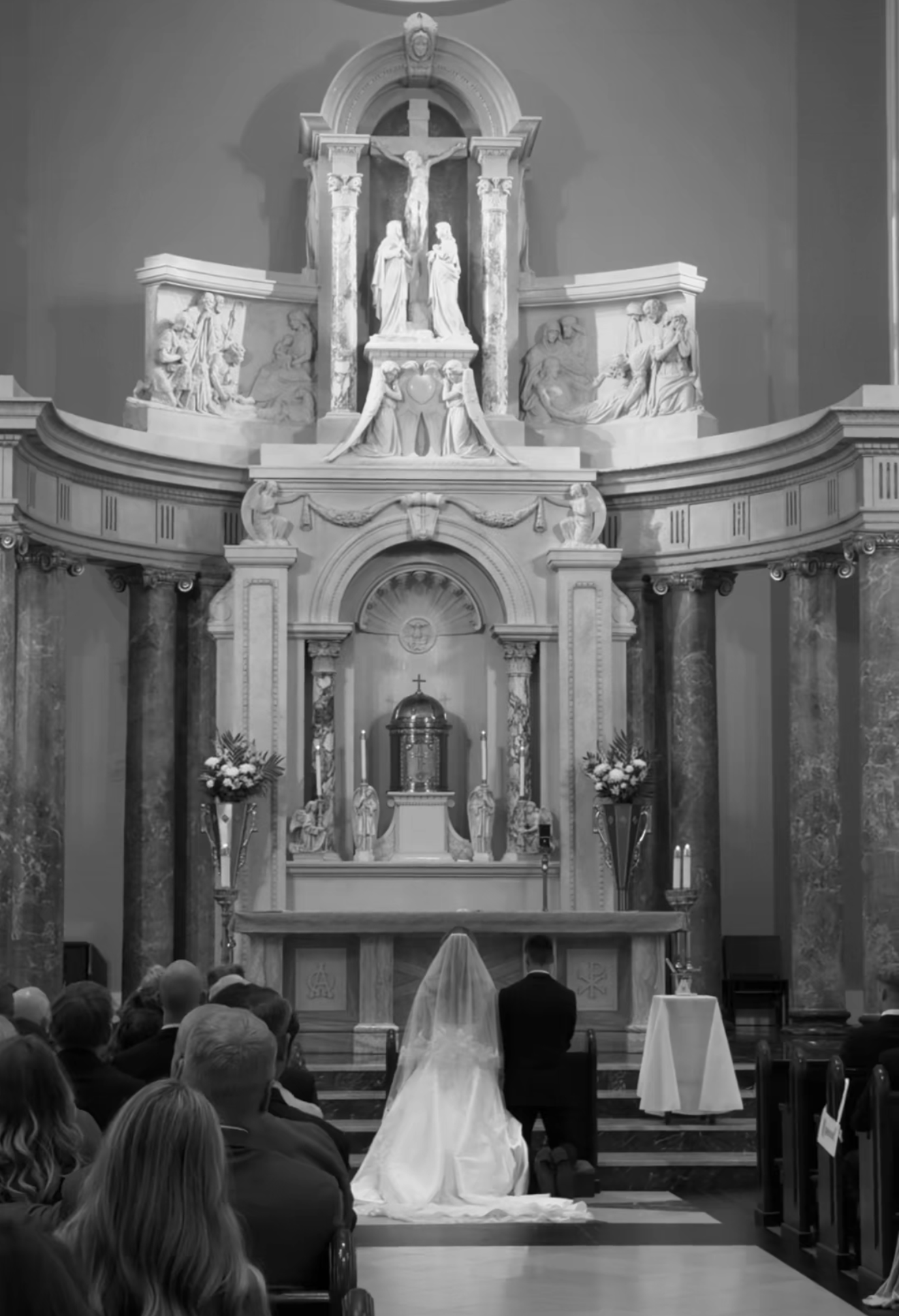 Bride and groom kneeling at the marble altar during the ceremony