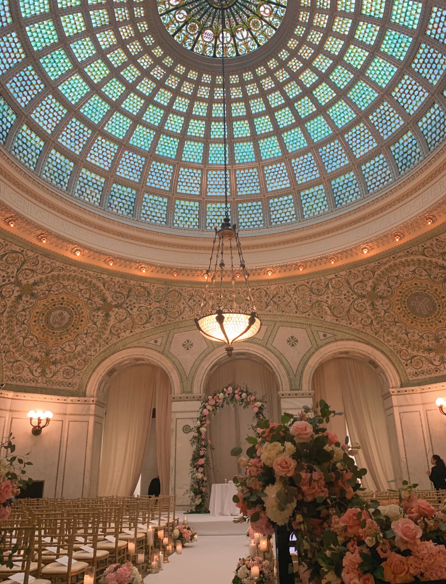 Ceremony beneath a stained glass dome with floral arch