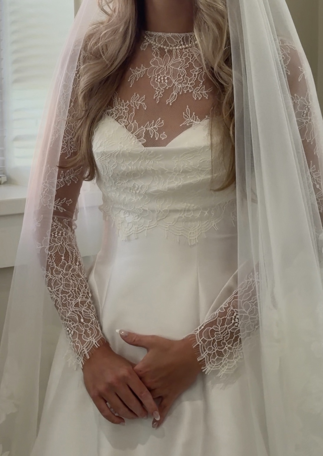 Close detail of a lace bodice, illusion neckline and cathedral veil