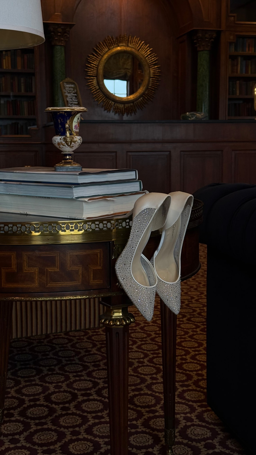 Crystal-embellished bridal heels resting on an antique library table
