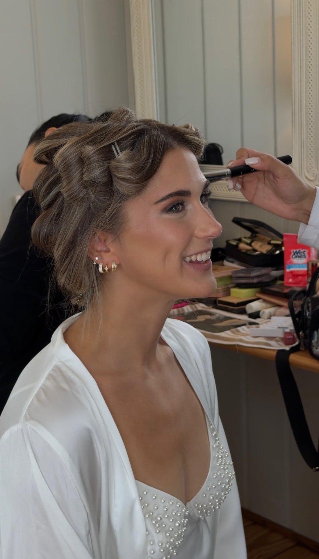 Bride smiling while makeup is applied