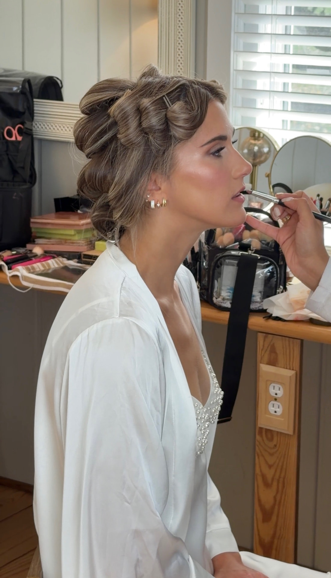 Bride having lipstick applied during getting ready
