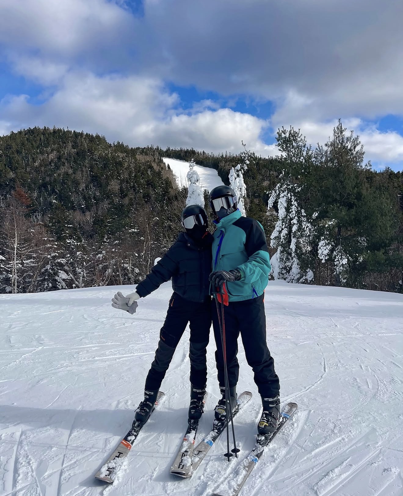 Couple on skis at the top of a snowy mountain