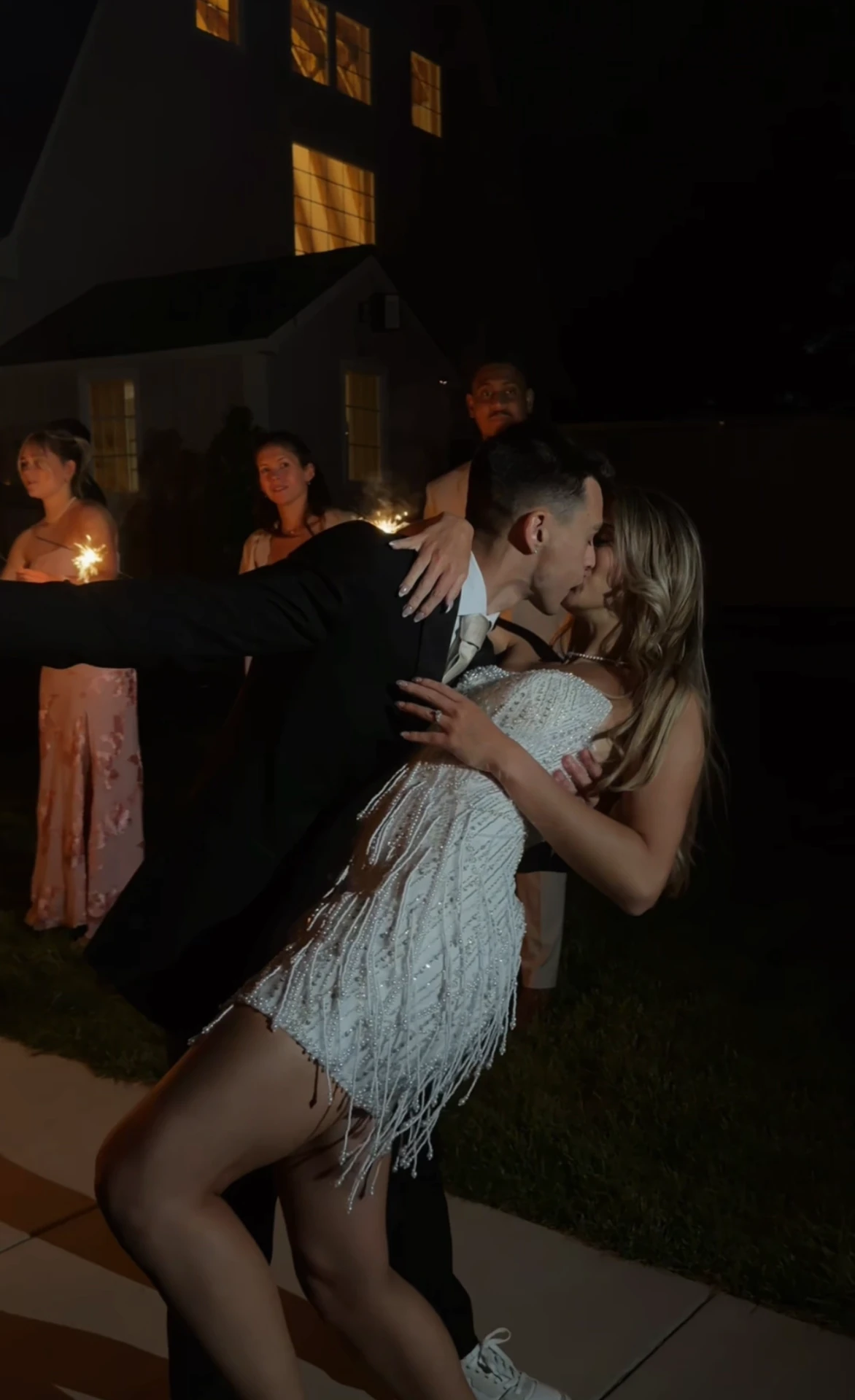 Couple kissing during sparkler send-off