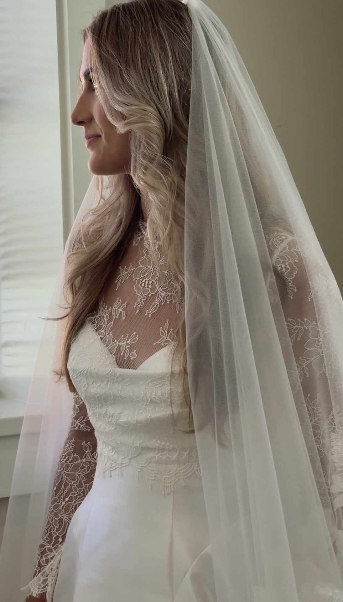 Bride in profile beneath her veil in soft window light