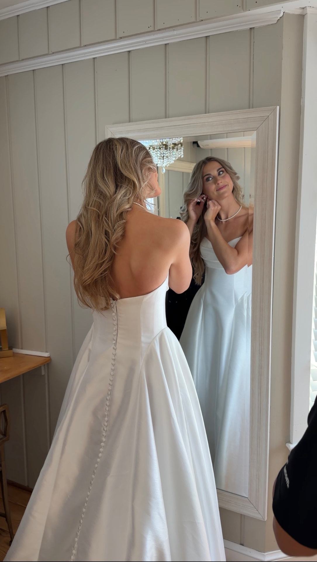 Bride in her gown looking into the mirror